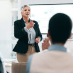 Business people, feedback and woman with presentation, seminar and questions with partnership, talent, corporate training and discussion.