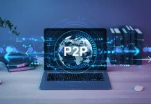 Laptop showing holographic globe with P2P text, digital light effects, on wooden desk in office