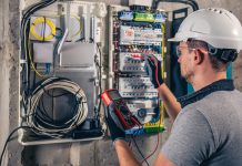 Electric technician working switchboard with fuses